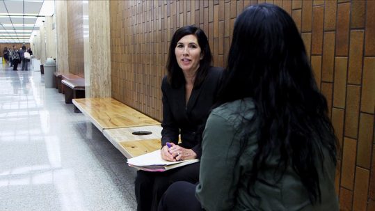 deputy public defender nancy chand speaks with a client